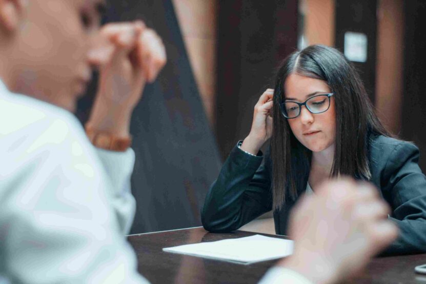 Woman wearing glasses reviewing paperwork during a legal consultation.