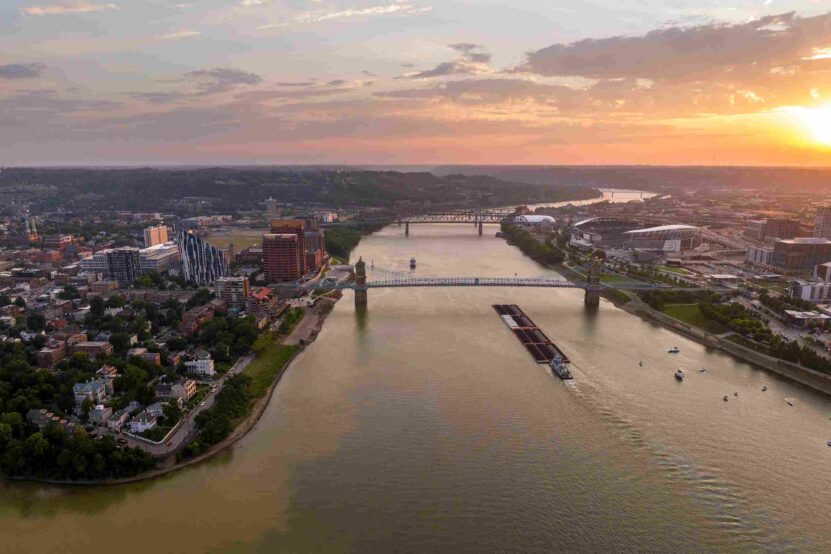 Aerial view of the Ohio River and bridges connecting Newport, Kentucky, and Cincinnati, Ohio, at sunset.